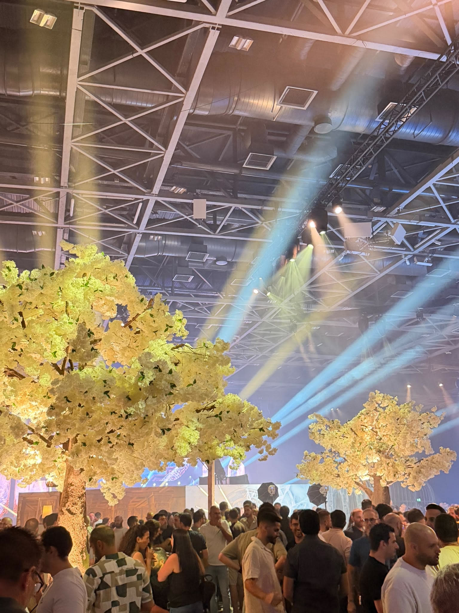 Guests at an end-of-year gala with blossom trees and stage lighting